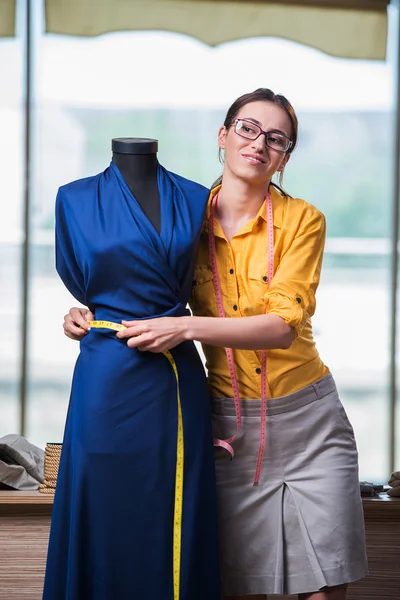 Mulher alfaiate trabalhando em roupas novas — Fotografia de Stock