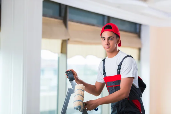 Jovem pintor pintando o teto no conceito de construção — Fotografia de Stock