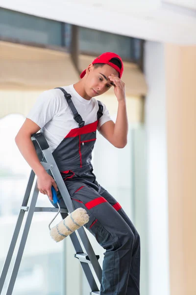 Joven pintor pintando el techo en concepto de construcción —  Fotos de Stock