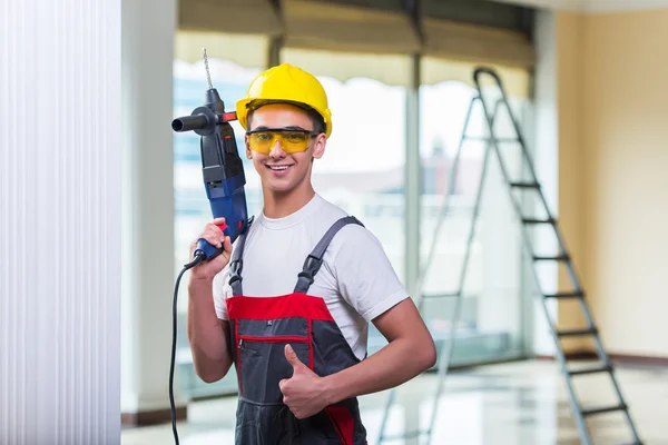 Homme forant le mur avec perforateur de forage — Photo