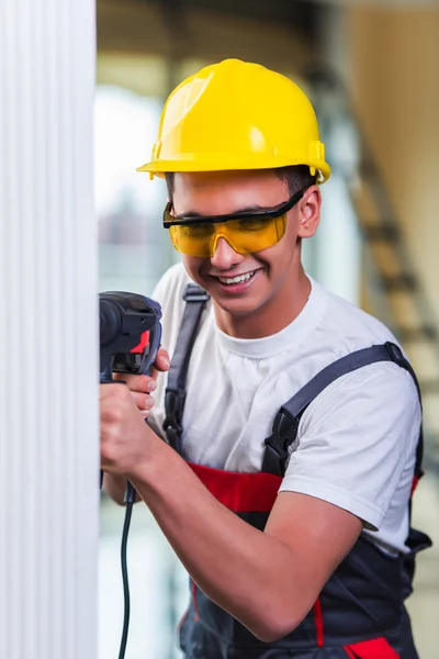 Uomo foratura del muro con perforatore — Foto Stock