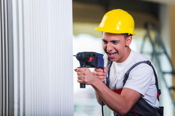 Mand boring væggen med bore perforator - Stock-foto