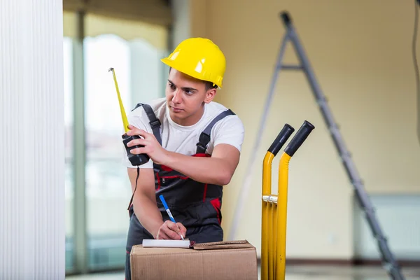 Entrega hombre tomando dimensiones con cinta métrica —  Fotos de Stock