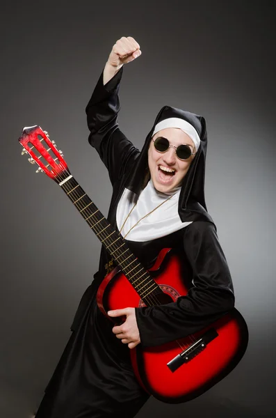 Monja divertida con guitarra roja tocando — Foto de Stock