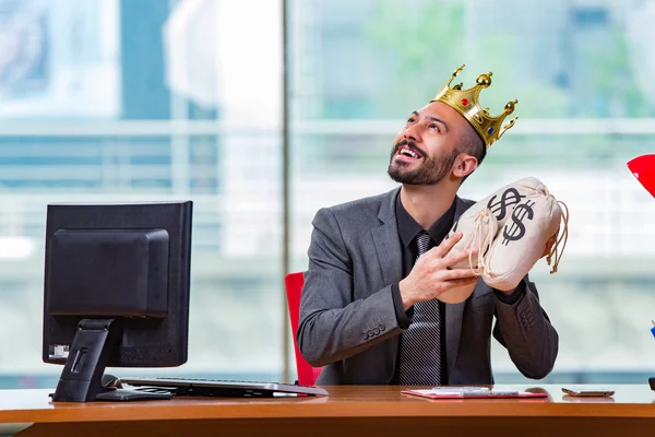 Homme d'affaires avec couronne et sacs d'argent dans le bureau — Photo