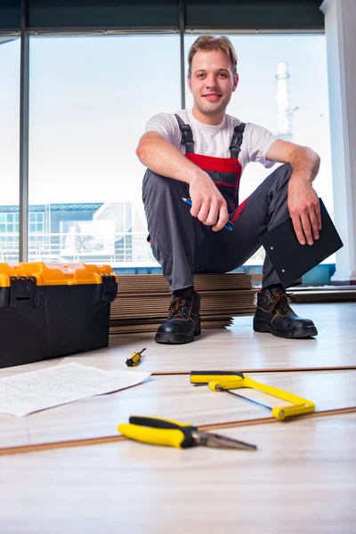 Hombre colocación de pisos laminados en concepto de construcción — Foto de Stock