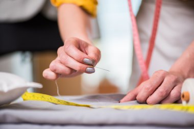 Terzi eller iş üzerinde yeni elbisesi