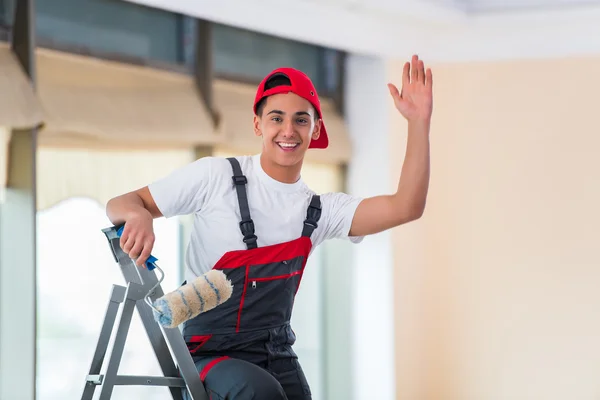 Jovem pintor pintando o teto no conceito de construção — Fotografia de Stock