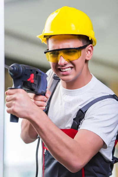 Mann bohrt mit Bohrmaschine in Wand — Stockfoto