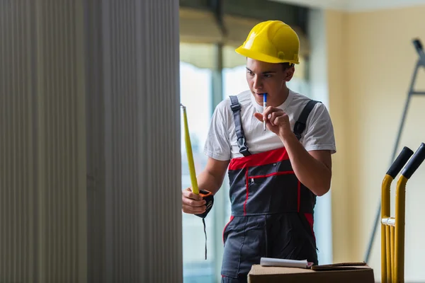 Entrega homem tomando dimensões com fita métrica — Fotografia de Stock