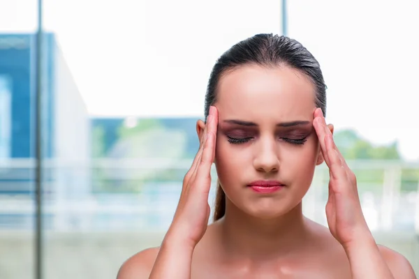 Mujer joven sosteniendo sus sienes con dolor de cabeza —  Fotos de Stock