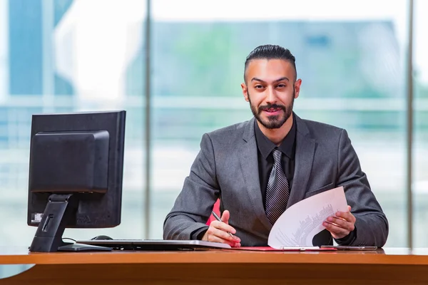 Homem de negócios feliz sentado na mesa — Fotografia de Stock