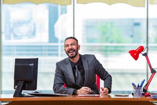 Счастливый бизнесмен сидит за столом — стоковое фото