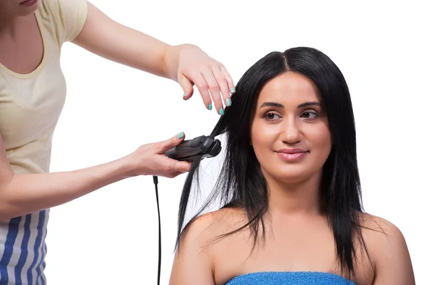 Jovem mulher recebendo alisador de cabelo isolado no branco — Fotografia de Stock
