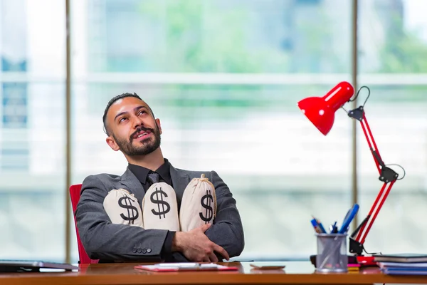 Empresário feliz com sacos de dinheiro no escritório — Fotografia de Stock