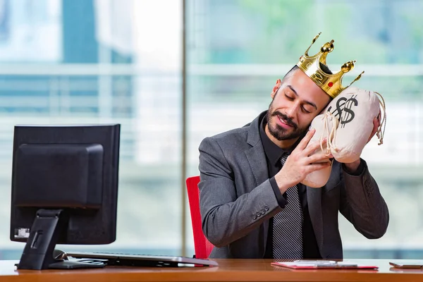 Бізнесмен з короною і грошовими мішками в офісі — стокове фото