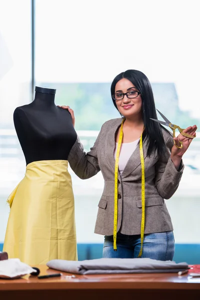 Mulher alfaiate trabalhando em roupas novas — Fotografia de Stock