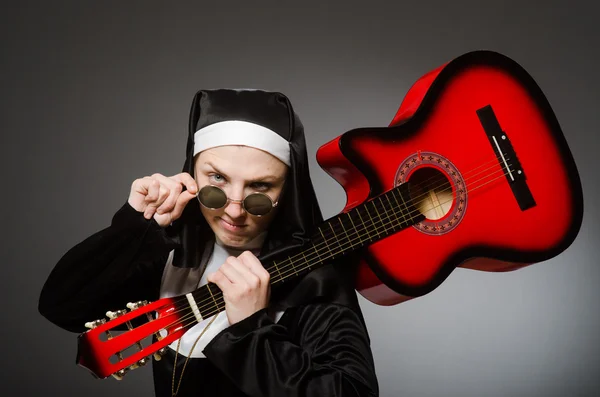 Monja divertida con guitarra roja tocando — Foto de Stock
