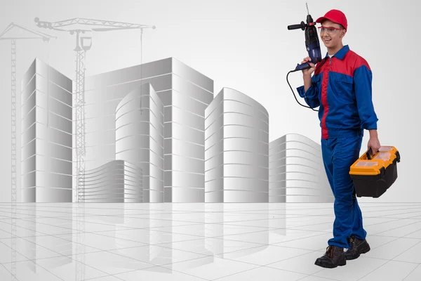 Man with drill against hand-drawn buildings — Stock Photo, Image