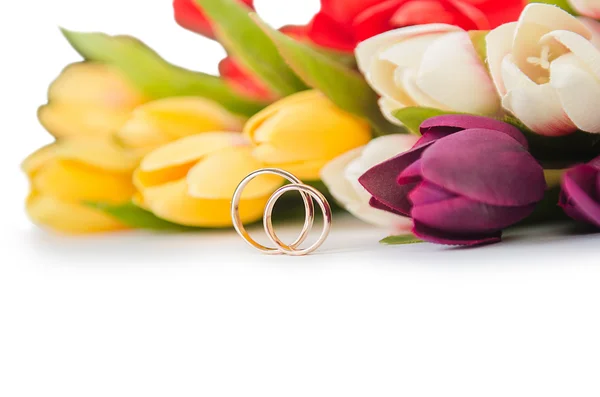 Anneaux de mariage et fleurs isolés sur fond blanc — Photo