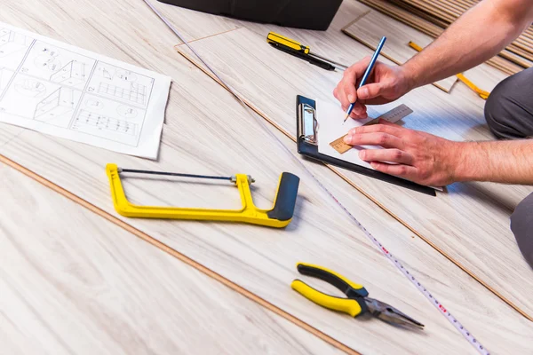 Homme pose stratifié plancher dans le concept de construction — Photo