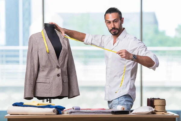 Jovem alfaiate trabalhando em novo design de roupas — Fotografia de Stock