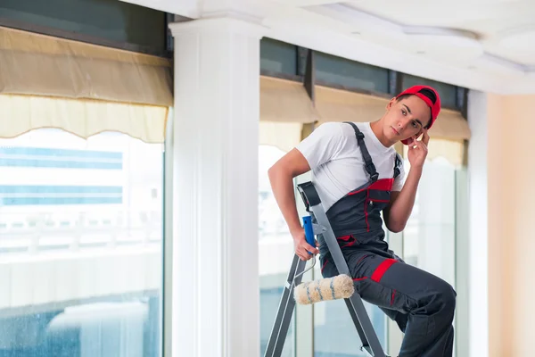 Giovane pittore dipingere il soffitto nel concetto di costruzione — Foto Stock