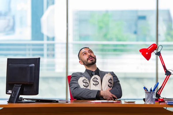 Empresário feliz com sacos de dinheiro no escritório — Fotografia de Stock