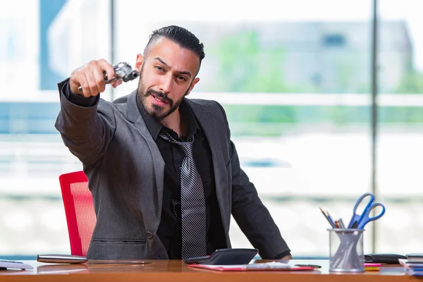 Angry aggressive businessman with gun in the office — Stock Photo, Image