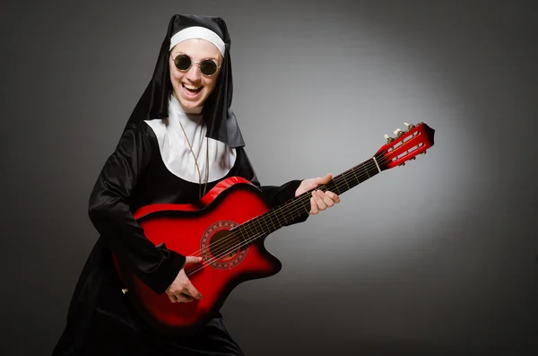 Freira engraçada com guitarra vermelha tocando — Fotografia de Stock