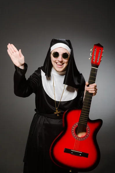 赤いギターを遊んで面白い修道女 — ストック写真
