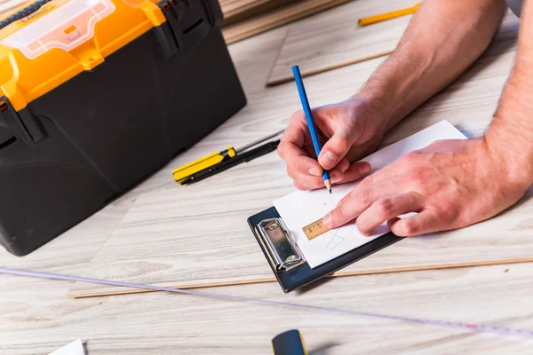 Homme pose stratifié plancher dans le concept de construction — Photo