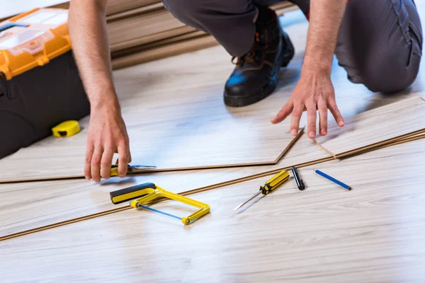 Mann verlegt Laminatboden im Baukonzept — Stockfoto