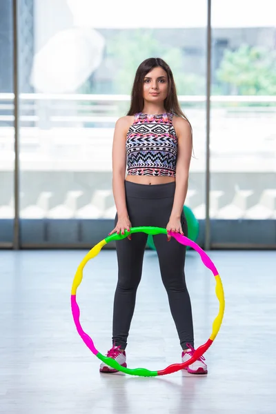 Giovane donna con hula loop in palestra nel concetto di salute — Foto Stock