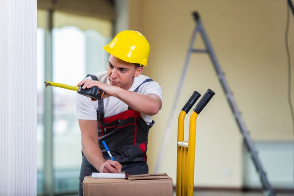 Entrega hombre tomando dimensiones con cinta métrica — Foto de Stock