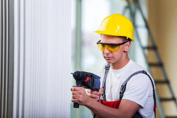 Uomo foratura del muro con perforatore — Foto Stock