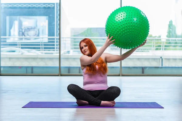 Woman working with swiss ball in the studio