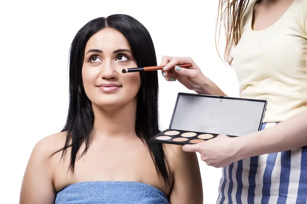 Junge Frau bekommt Make-up isoliert auf weiß — Stockfoto