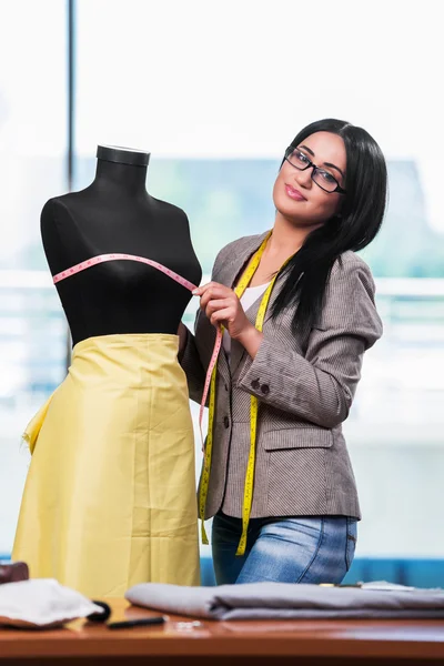 Mulher alfaiate trabalhando em roupas novas — Fotografia de Stock