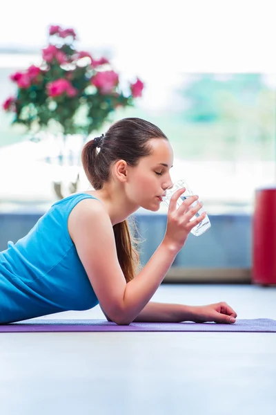 Femeia tânără bea apă în sala de gimnastică concept de sănătate — Fotografie, imagine de stoc