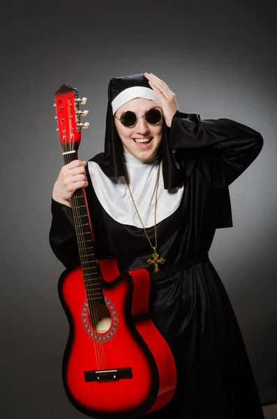 Freira engraçada com guitarra vermelha tocando — Fotografia de Stock