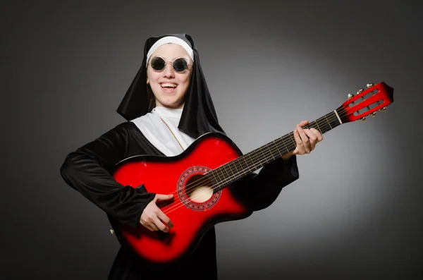 Funny nun with red guitar playing — Stock Photo, Image