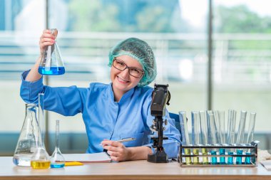 Kimyasal çözümler üzerinde çalışan deneyimli asistan