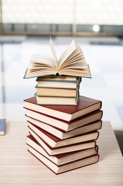 Pilha de livros arranjou a mesa de escritório — Fotografia de Stock