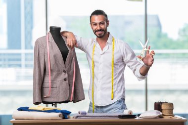 Genç terzi yeni kıyafet tasarımı üzerinde çalışıyor.