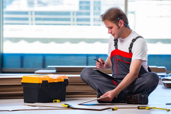 Man laying laminate flooring in construction concept — Stock Photo, Image