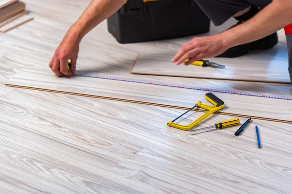 Ember építési koncepcióját laminált padló fektetése — Stock Fotó