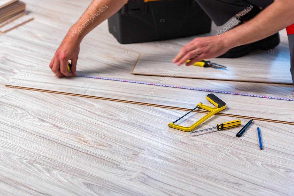 Man Laying Laminate Flooring In Construction Concept Stock Photo Man Laying Laminate Flooring In Construction Concept Stock Photo