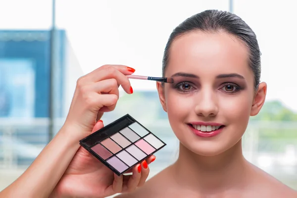 Mujer hermosa durante la sesión de cosméticos de maquillaje — Foto de Stock