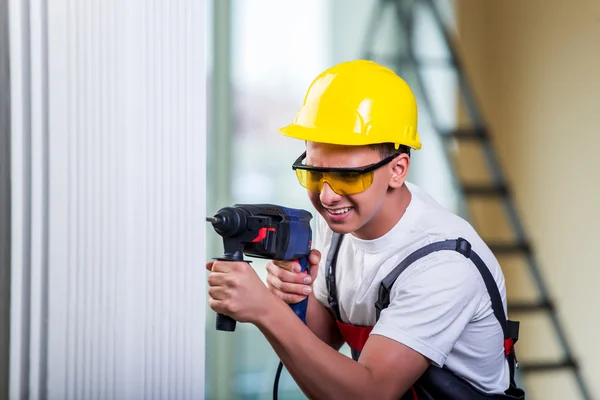 Mand boring væggen med bore perforator - Stock-foto